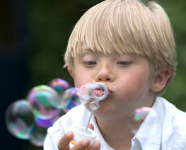 Down syndrome child blowing bubbles