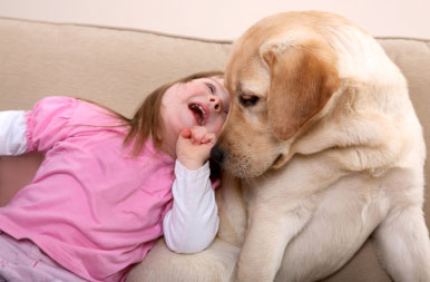 Down syndrome girl playing with dog