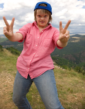 Adolescent girl with Down syndrome on top of mountain