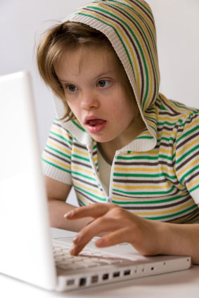 Girl child with Downs syndrome on laptop