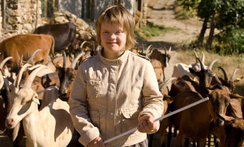 Teenage girl with Downs syndrome on a farm with a goat herd